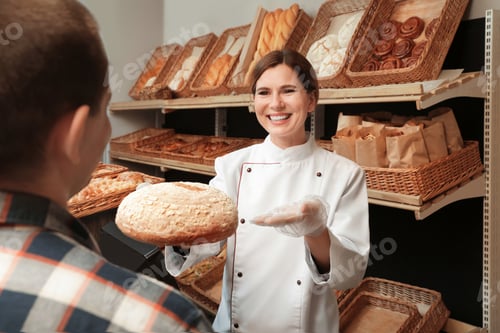 Preview: Baker giving customer fresh bread in store