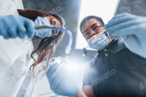 Preview: Male and female dentists working in the office together. First person view
