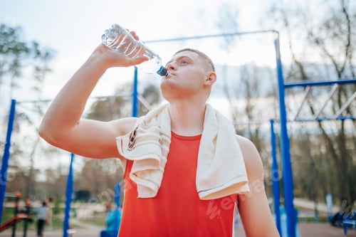 Preview: Sweat It Out Male Sportsman Drinks Water During Outdoor Workout.
