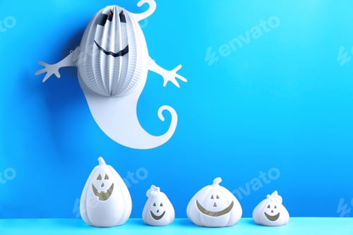 Preview: Composition with pumpkin shaped candle holders on blue background. Halloween decoration
