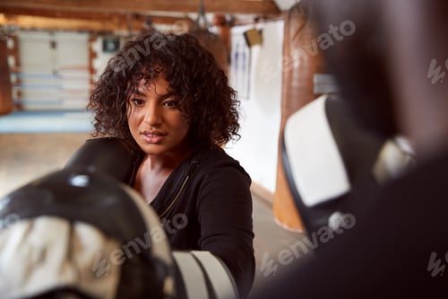 Preview: Male Personal Trainer Sparring With Female Boxer In Gym Using Training Gloves