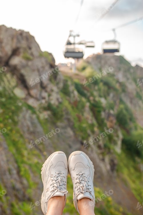 Preview: Close-up of female legs in sneakers on the grass outdoors in the park