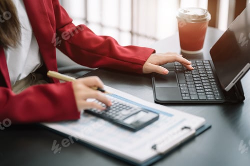 Preview: Business women using a calculator to calculate