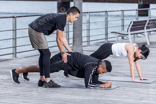 Preview: Adult man helping man and woman with plank