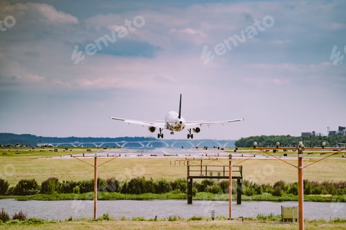 Preview: Closeup of an airplane flying over a field in the airport