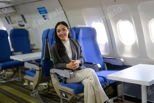 Preview: Asian woman smiling, traveling in business class cabin
