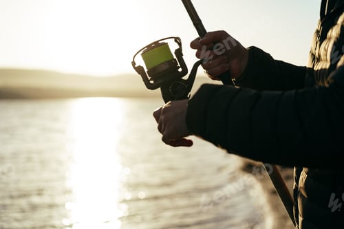 Preview: Fisherman hands holding fishing rod close up
