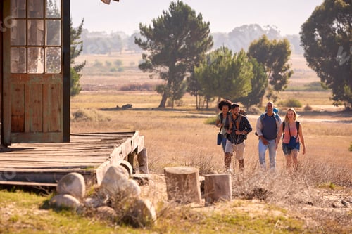 Preview: Group Of Friends With Backpacks Hiking In Countryside Together