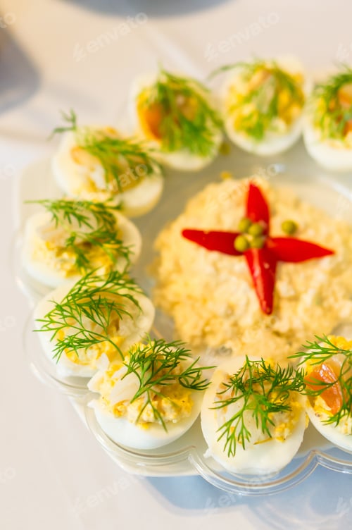 Preview: Vertical shot of half-cut cooked eggs with filling on a plate