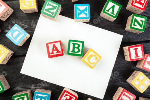 Preview: Toy cubes with letters on wooden background, copy space