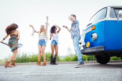Preview: Happy friends driving a vintage minivan