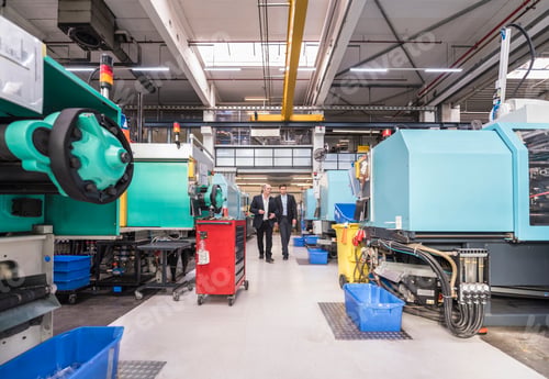 Preview: Two men walking and talking in factory shop floor