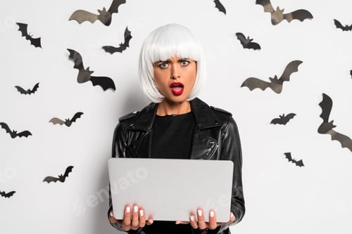 Preview: shocked woman in white wig holding laptop in Halloween