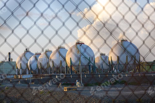 Preview: Large industrial oil tanks stand side by side in a factory setting