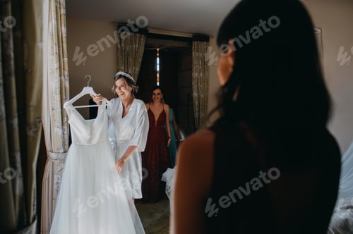 Preview: Bride presenting the dress to her bridesmaids