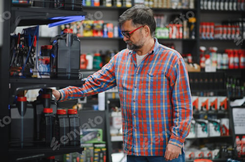 Preview: Mechanic choosing engine oil in auto parts store