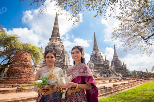 Preview: Asian woman wearing ancient Thai traditional dress holds garland and fresh flowers paying homage Bud