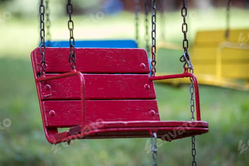 Preview: Close-up of empty wooden blue, yellow, vintage seats of multi-colored carousel hanging on chains