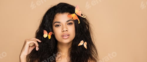 Preview: young african american woman with orange butterflies on hair isolated on beige, banner