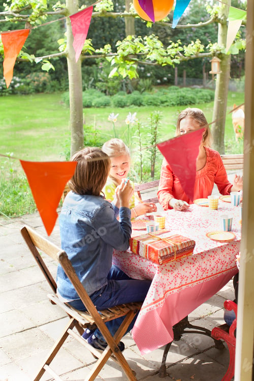 Preview: Mother chatting with children at patio table