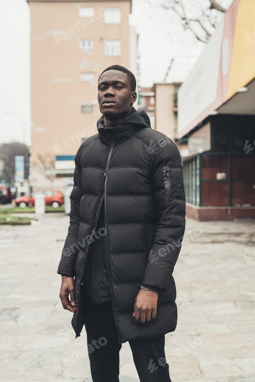 Preview: portrait of young african man standing in the street and looking camera