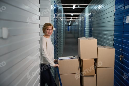 Preview: Woman standing by large trolley filled with stacked boxes