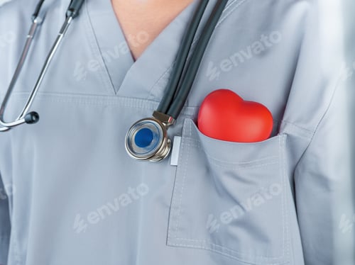 Preview: Man doctor cardiologist holding red heart in pocket of surgical suit and phonendoscope on grey backg
