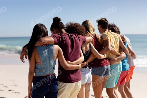 Preview: Multi-ethnic group of male and female standing on the beach