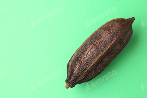Preview: Cocoa pod on green background, top view. Space for text