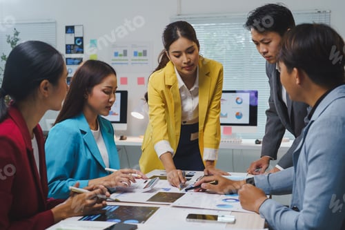 Preview: Business team collaborating in an office setting, analyzing financial charts and reports while discu