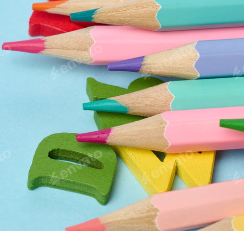 Preview: Wooden pencils and wooden letters on blue background, school supplies