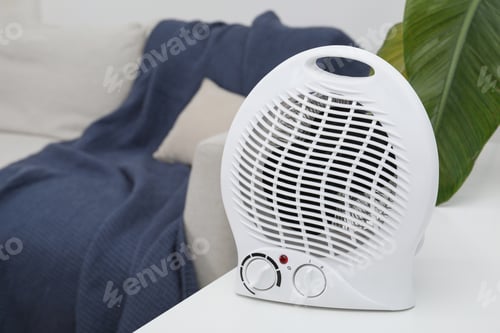 Preview: Portable electric fan heater near sofa indoors