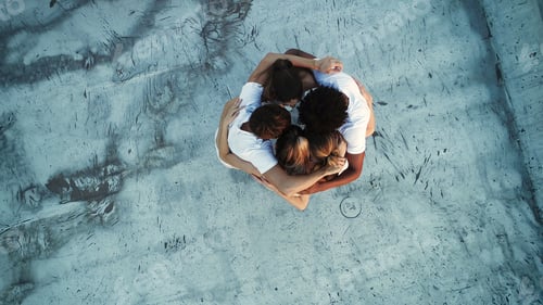 Preview: Young diverse people embracing uniting in circle standing together