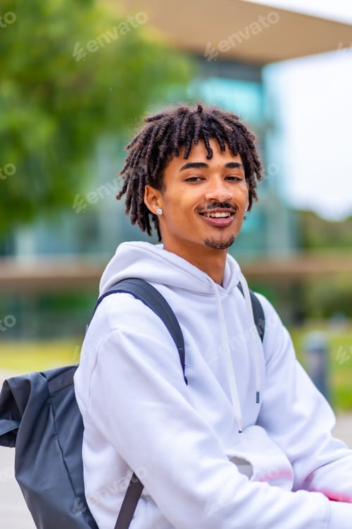 Preview: African american student with dreadlocks smiling sitting outside the university