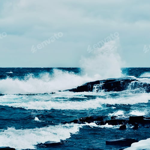 Preview: A wave crashing on a rock splashing into a cloudy sky