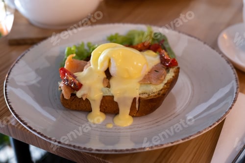Preview: Breakfast sandwich of toasted bread, poached egg, tomato and melted cheese.