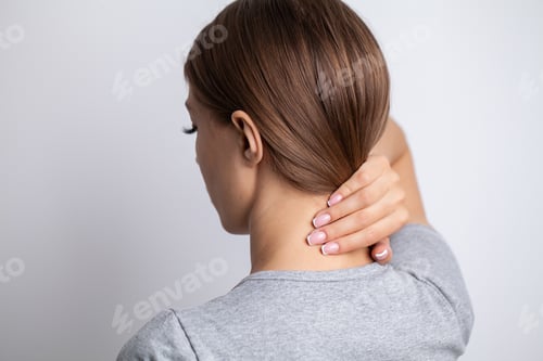 Preview: Sick woman suffering from sore neck on gray background
