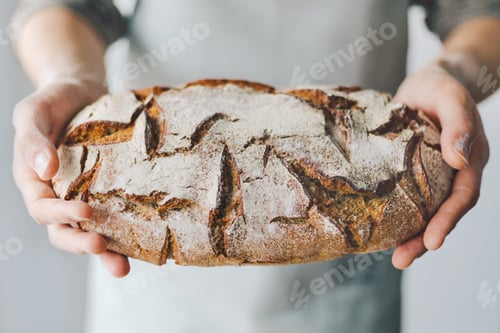 Preview: Baker or chef holding fresh made bread