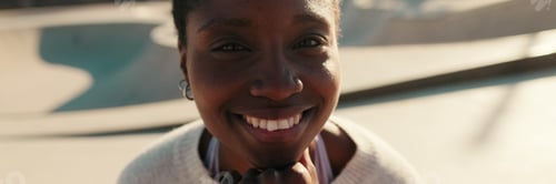 Preview: Сlose-up of happy calm young woman spending time skatepark. Panoramic