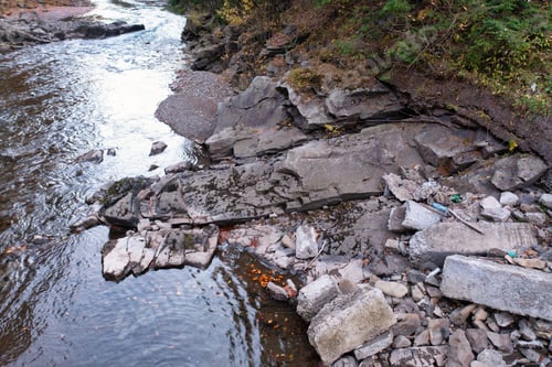 Preview: River stream running past mountain foot with autumn forest
