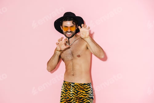 Preview: Young shirtless man wearing shorts grimacing and gesturing at camera
