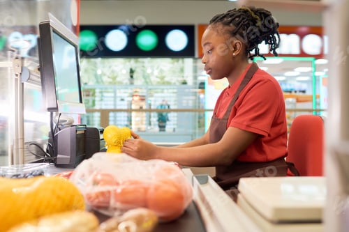 Preview: Young female shop assistant scanning fresh lemons in bag by counter