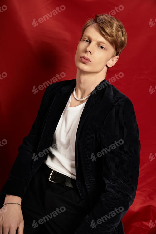 Preview: Young handsome man embodies modern masculinity against vibrant red backdrop
