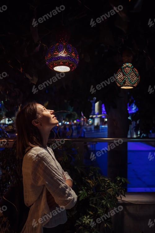 Preview: Woman looking at the lamps in the dark