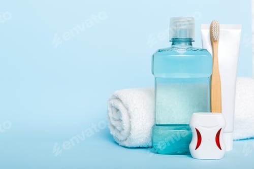 Preview: Mouthwash and other oral hygiene products on colored table top view with copy space