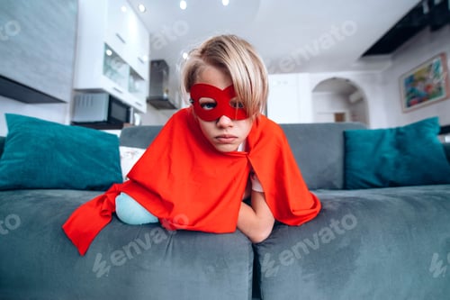 Preview: Superhero child sitting on sofa at home