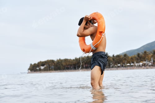 Preview: Summer Beach Safety: Alert Asian Lifeguard Saver on Duty, Rescuing Swimmers at Sea