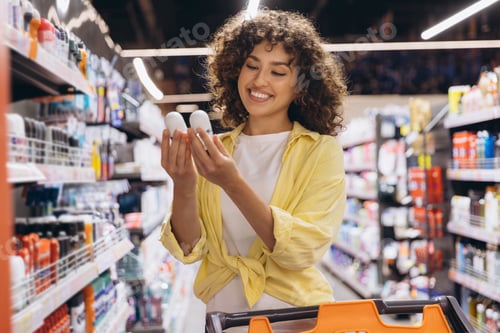 Preview: Smiling Woman Choosing Deodorant in Supermarket