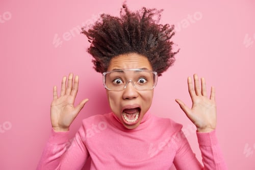 Preview: Studio shot of stupefied emotional crazy woman raises palms keeps jaw dropped stares terrified screa