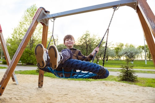 Preview: Happy boy playing with swing cobwebs in the playground. Children Activities outdoors